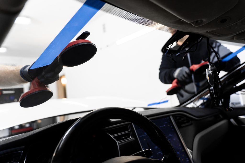 Techniciens en train de remplacer un pare-brise sur un véhicule